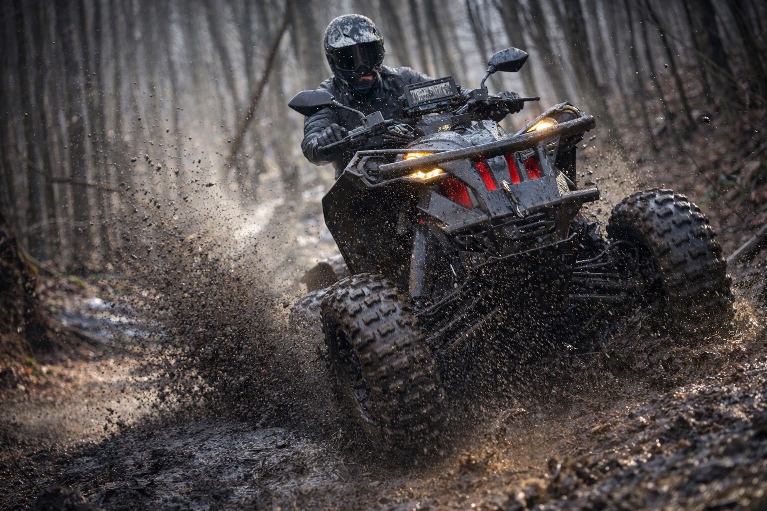 ATV rider splashing through a muddy forest trail